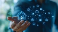 Glowing house icons floating above open palm against blue background illustrates smart home technology and digital real estate network connectivity.