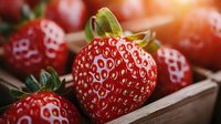Fresh ripe strawberries with natural texture and seeds in wooden box, macro shot with soft focus background showing juicy red fruit details.