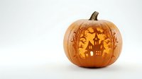 Carved Halloween pumpkin with spooky haunted house silhouette and bats glowing from within on white background for autumn seasonal decorations.