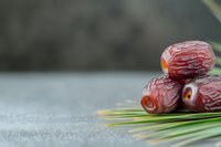 Fresh dates fruit on palm leaves with copy space for healthy organic food and nutrition concepts.