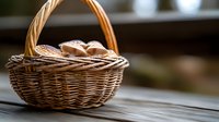 Fresh bread rolls in rustic woven wicker basket on wooden table surface with soft natural lighting and shallow depth of field creating cozy atmosphere.