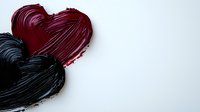 Red and black painted hearts on white background, textured brush strokes create romantic artistic composition with dramatic contrast and empty space for text.