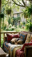 Cozy outdoor porch swing with colorful bohemian textiles and hanging plants creating peaceful garden retreat atmosphere for relaxation and home decor inspiration.