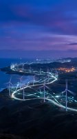 Wind turbines with glowing energy connections at dusk showcasing renewable power grid technology and sustainable electricity generation in rural landscape.