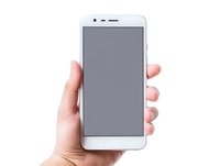 Caucasian female hand holding modern white smartphone with blank screen against white background, isolated mockup for app and web design presentation.
