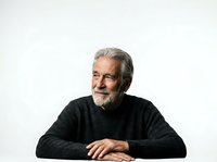 Senior man with gray hair and beard wearing dark sweater, isolated on white background for portrait, corporate, or editorial use.