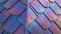 Iridescent metal roof tiles with holographic gradient finish displaying purple, blue, and pink tones. Overlapping shingles create dimensional pattern for architectural and design projects.