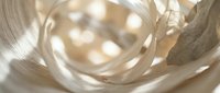 Close-up of clear glass sphere with warm bokeh light reflections and soft neutral fabric textures, suitable for luxury product backgrounds and cosmetic packaging design.