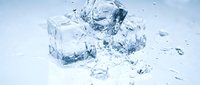 Crushed ice cubes scattered on white surface with frozen water splashes and shards, suitable for beverage, refreshment, and cooling product advertising.