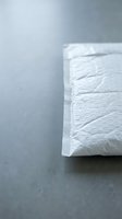White paper napkin with textured surface on gray background for hygiene and dining concepts.