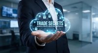 Businessman holding glowing trade secrets cloud with security locks in modern office environment representing confidential business information protection.