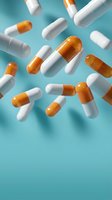 Orange and white pharmaceutical capsules floating on turquoise background for medical healthcare and medicine industry concepts.