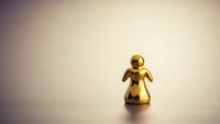 Golden angel figurine on soft beige surface with warm lighting creating peaceful spiritual atmosphere for holiday decorations and religious concepts.