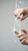 Two hands reaching toward each other with glowing network connections and light effects symbolizing digital communication, teamwork and technological collaboration.