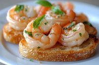 Succulent shrimp garnished with fresh herbs served on crispy toasted bread, close-up view of gourmet appetizer on white plate, selective focus.