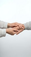 Two people joining hands in supportive gesture on white background, showing teamwork, partnership and cooperation in business or personal relationships.