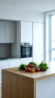 Modern minimalist kitchen interior with wooden island, fresh vegetables, built-in appliances and clean white cabinetry for contemporary home design.