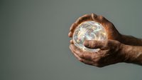 Hands holding glowing crystal ball against neutral background, symbolizing fortune telling, divination, spirituality and future prediction for mystical concepts.