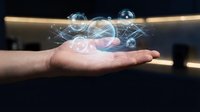 Hand holding holographic digital network with glowing spheres and connecting lines representing futuristic technology, innovation and data visualization concepts.
