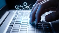 Business professional typing on laptop with digital gear icons representing automation, technology innovation and workflow optimization in modern office.