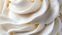 Creamy white frosting swirls with smooth texture and elegant curves for baking, dessert decoration, and culinary design projects.