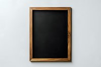 Empty black chalkboard with wooden frame on white wall background, clean slate ready for text or drawings, minimalist education concept.