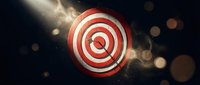 Red and white bullseye target with arrow hitting center against dark background with golden bokeh lights for business success concepts.