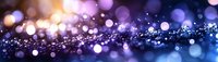 Magical glowing bokeh lights on dark background with sparkles and blurred circles creating dreamy atmospheric effect. Purple and blue tones with golden glow.