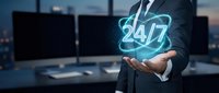 Professional businessman in suit holding glowing 24/7 neon sign in modern office environment representing round-the-clock customer service and support.