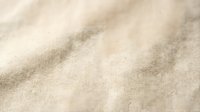 Natural beige linen fabric texture with soft wrinkles and folds, organic cotton material background for textile design and home decor projects.
