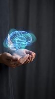 Glowing holographic brain floating above cupped hands representing artificial intelligence, mental health, neuroscience and cognitive technology concepts.