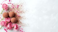 Chocolate truffles with pink roses and cocoa powder scattered on white background, creating romantic dessert composition for confectionery advertising or menu design.