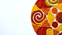 Colorful spice powder mandala with turmeric, paprika and chili creating decorative circular pattern on white background for culinary and wellness designs.