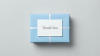 Light blue gift box with white ribbon and a Thank You card on top, shot from above on a neutral background.