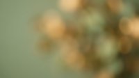 Abstract blurred bokeh background with warm golden and green tones creating soft dreamy atmosphere for design projects and overlays.