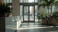Modern office lobby interior with large windows, natural sunlight, and tropical plants creating professional workspace atmosphere for corporate design.