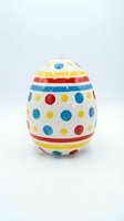 Colorful ceramic Easter egg with polka dots and stripes isolated on white background for holiday decorations and spring celebrations.