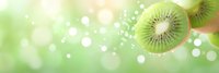 Fresh kiwi slices on soft green bokeh background with glowing light effects and sparkles. Banner format composition for healthy food and fruit concepts.