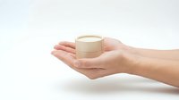Female hands holding luxury skincare cream jar with gold cap against white background for beauty and cosmetics advertising campaigns.