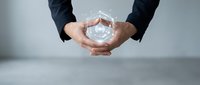 Business professional cupping hands around glowing light bulb symbolizing innovation, creativity and bright ideas for corporate success and entrepreneurship.