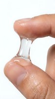 Transparent stretchy slime or putty being pulled between two fingers, demonstrating elasticity and viscosity for educational, scientific, or product demonstration purposes.
