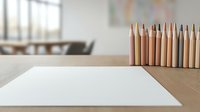 Blank white paper sheet on wooden desk with colored pencils in bright office workspace for creative projects and artistic work.