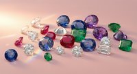 Collection of precious gemstones including diamonds, sapphires, emeralds and rubies in various cuts scattered on pink surface for luxury jewelry design.
