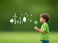 Young boy in green shirt blowing dandelion with environmental icons appearing, symbolizing renewable energy and conservation against blurred green background.
