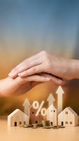 Protective hands over wooden house models with percentage symbols and upward arrows representing real estate investment growth and property insurance coverage.