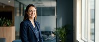 Professional businesswoman smiling confidently in modern office environment with natural lighting and contemporary workspace design for corporate success.