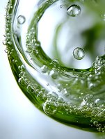 Macro shot of swirling water and air bubbles in green liquid creating dynamic spiral pattern with transparent spherical droplets against white background.