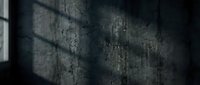 Dramatic window light casting geometric shadows on weathered concrete wall creating moody atmospheric interior background for design projects.