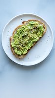 Fresh avocado toast with sesame seeds on sourdough bread served on white plate, healthy breakfast meal for restaurant menu and food blog content.