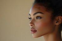 Young African American woman with flawless skin and natural makeup in profile view against neutral background for beauty and skincare concepts.